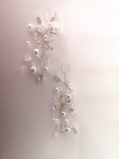 Perl-Ohrringe mit transparenten und silbernen Akzenten, elegant und filigran gestaltet.